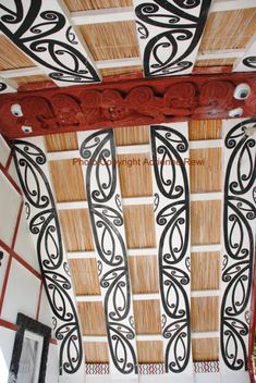 the ceiling is decorated with black and white designs on bamboo rafters, along with red trimmings