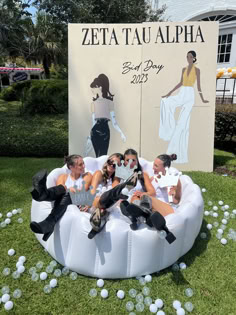 four women sitting on an inflatable chair at the zeta tau aloha