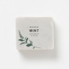 a bar of mint soap sitting on top of a white surface