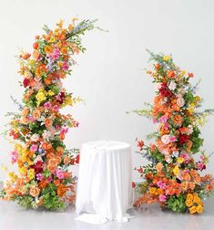 an arrangement of colorful flowers on top of a white table