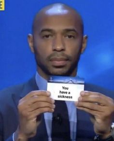 a man in a suit and tie holding up a card