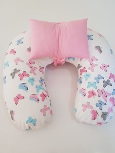 a pillow shaped like a donut with pink and blue butterflies on it's side