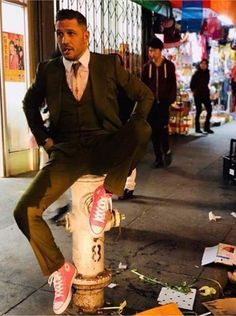 a man in a suit leaning on a fire hydrant