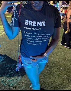 a woman in blue shorts and a black t - shirt is standing on the grass