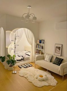 a living room filled with furniture and a white rug on top of a hard wood floor