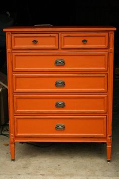 an orange chest of drawers in a garage