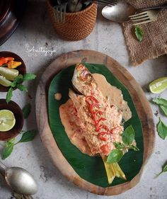 a green plate topped with food on top of a wooden board next to utensils