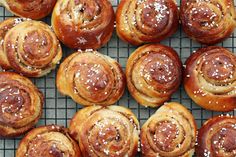 many different types of pastries on a cooling rack with sugar sprinkled on top