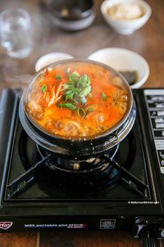 a bowl of soup sitting on top of a stove