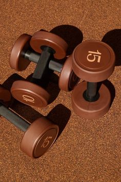 three brown dumbbells sitting on top of each other in the middle of a floor