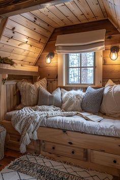 a bed with pillows and blankets on top of it in a room that has wooden walls