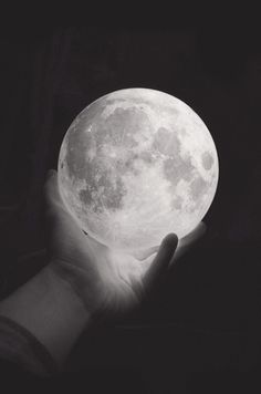 a person holding the moon in their hand