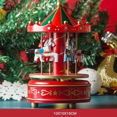 a merry go round toy sitting on top of a table next to a christmas tree