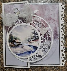 a christmas card with an ornament on it and a bow at the top