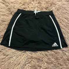 Nwot. Black With White Side Stripes. Athletic Skirt With Built-In Shorts. Side Slits. Elastic Waist With Tie And Cinch Waist. Size Small. 100% Polyester (Skirt) 91% Polyester, 9% Spandex (Shorts) 14.5" Waist 16" Length Cheap Navy Adidas Tops, Adidas Casual Summer Skirt, Black Mini Skirt For Sports, Spring Season, Adidas Fitted Casual Skirt, Summer Adidas Fitted Skirt, Adidas Casual Mini Skirt, Casual Adidas Mini Skirt, Fitted Adidas Mini Skirt, Athletic Skirt Outfit