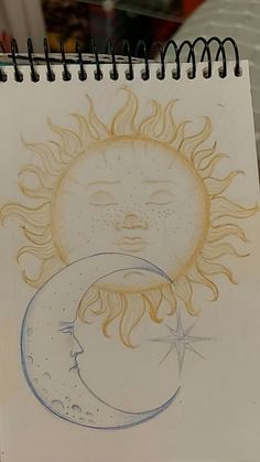 a drawing of the sun and moon on a notebook