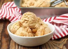 a bowl filled with ice cream sitting on top of a wooden table