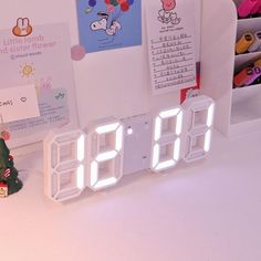 an alarm clock sitting on top of a table next to a christmas tree and toys