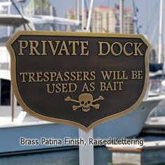 a sign that says private dock trespassers will be used as bat in front of some boats