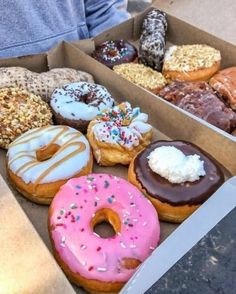 a box filled with lots of different flavored donuts