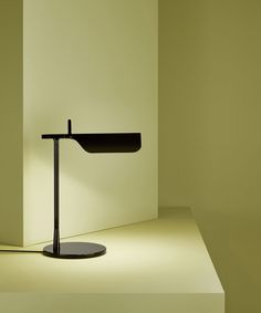 a table lamp sitting on top of a white floor next to a light green wall