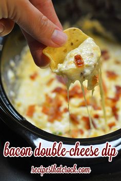 a person is dipping some food into a bowl with cheese and other toppings on it