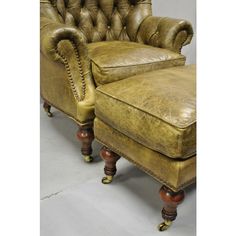 an old leather chair and footstool sitting next to each other