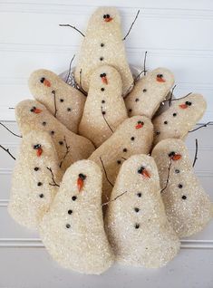 a group of snowmen sitting next to each other in front of a white wall