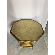 an octagonal brass table with marble top