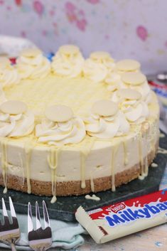 a cake with white icing and chocolate on top sitting next to other dessert items