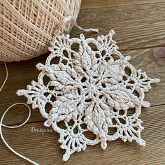 crochet snowflake ornament next to twine on wooden table