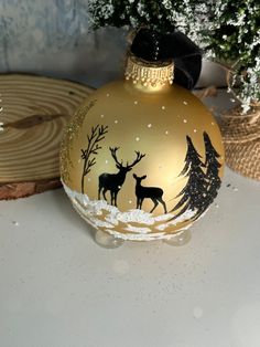 a christmas ornament with deer and trees on it