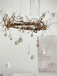 a chandelier made out of branches and eggs hanging from it's ceiling