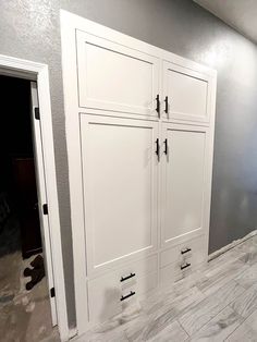 an empty room with white cabinets and gray walls