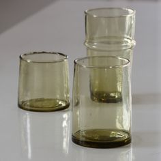 three glasses sitting on top of a white table