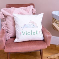 a pink chair with a white pillow that says violett on it and a bunny