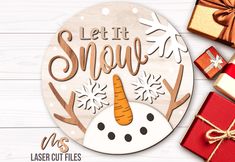 a snowman with a carrot on it next to presents and a wooden sign that says, let it snow us laser cut files