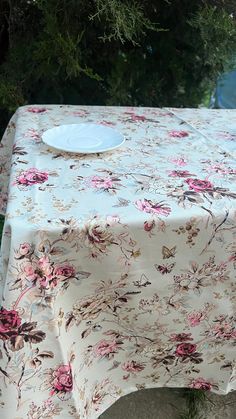 a white plate sitting on top of a table covered in pink flowers