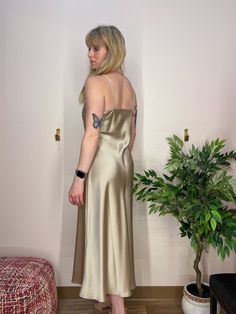 A beautiful gold slip dress, in a thick satin material, that shimmers and shines with movement. A beautiful dress for a wedding, rehearsal dinner, or cocktail party. Champagne Gold Silk Slip Dress V-Neckline, double layer fabric over bust Heavy Satin Material Silk V-neck Slip Dress For Prom, Gold V-neck Evening Dress For Summer, Glamorous Silk Slip Dress For Date Night, Bias-cut Satin Evening Dress For Date Night, Elegant Metallic Satin Evening Dress, Gold Satin Sleeveless Evening Dress, Elegant Shimmer V-neck Evening Dress, Bias Cut Satin Evening Dress For Date Night, Sleek Formal Dress With Subtle Sheen