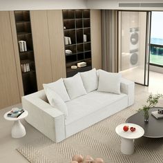 a living room filled with white furniture next to a large glass door leading to a balcony