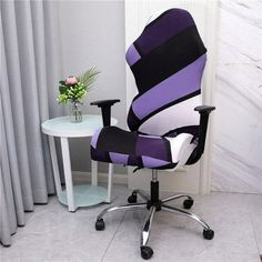 a purple and black office chair sitting next to a white table with flowers on it