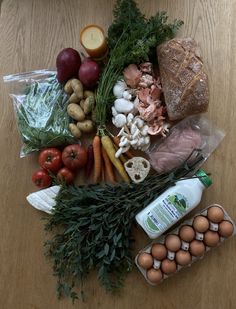 an assortment of food on a table including eggs, bread, vegetables and meats