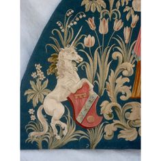 an intricately decorated wall hanging with a horse on it's hind legs and flowers in the background