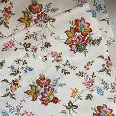 the fabric is white with colorful flowers on it