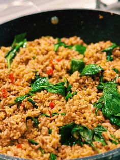 a pan filled with rice and spinach on top of a stove