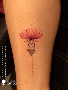 a woman's leg with a tattoo on it that has a pink flower in the middle