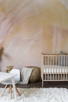 a baby's room with a crib, table and chair