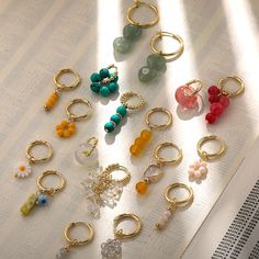 a bunch of rings sitting on top of an open book next to beads and charms