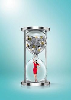 a woman in a red dress is standing under an hourglass with coins on it