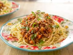 spaghetti with meat sauce and parsley on a floral plate, ready to be eaten